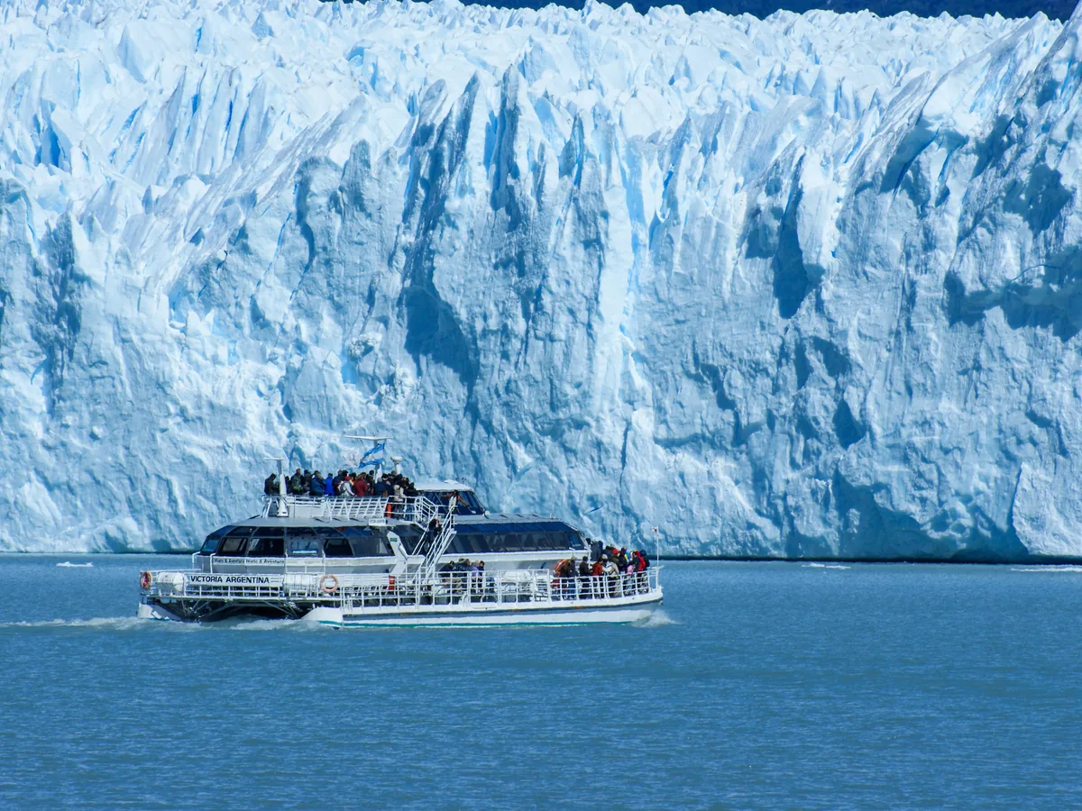 Turisté na lodi projíždějící kolem čela Ledovce Perito Moreno